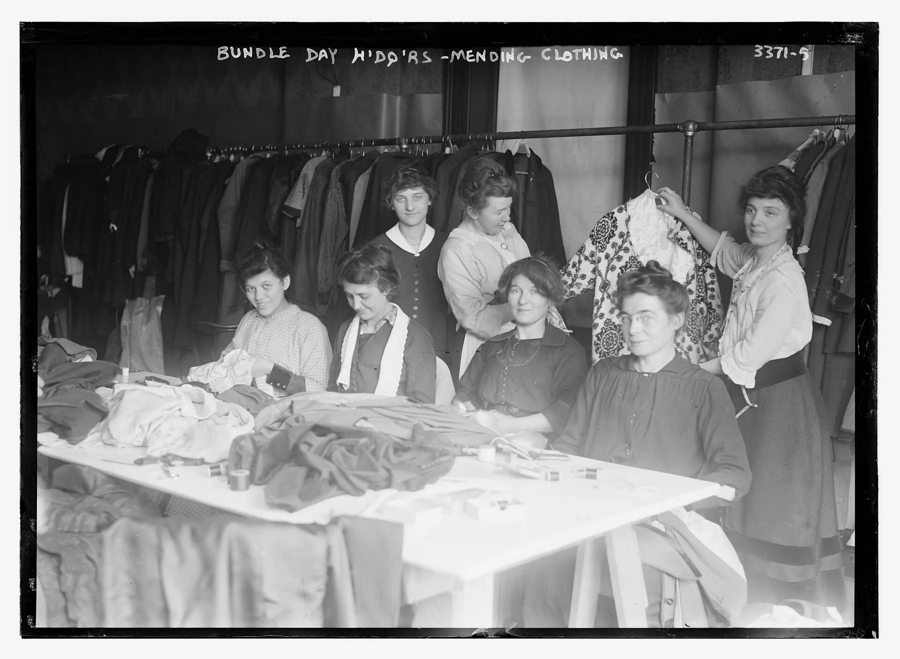 Archival photograph of people mending clothing together.