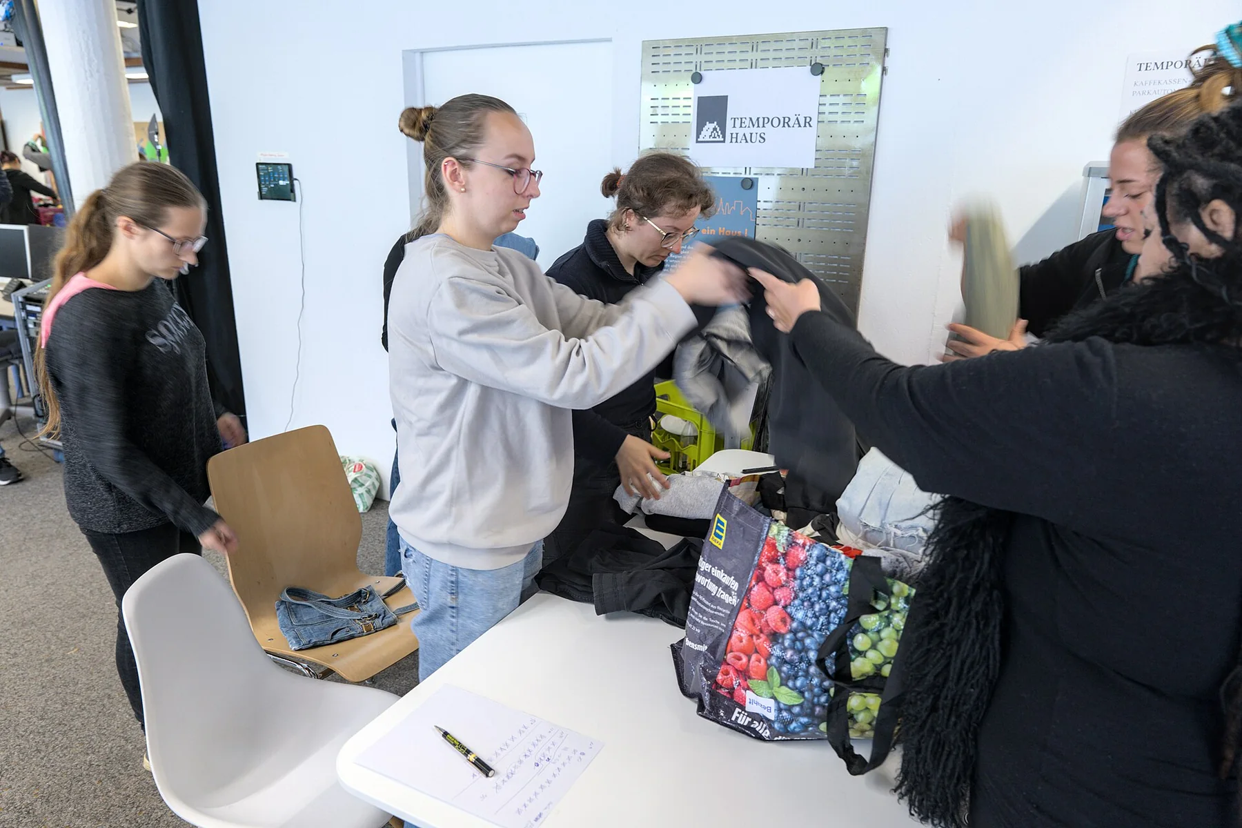 Garments are arranged for a community clothing swap.